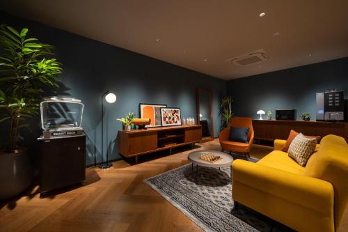 a living room with a yellow couch and a tv at Namba Oriental Hotel in Osaka