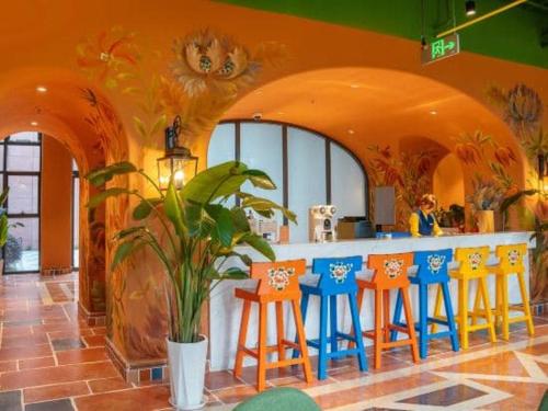 a restaurant with a bar with blue and orange stools at Xikang Wellness & Resort Qingcheng Mountain in Taiping