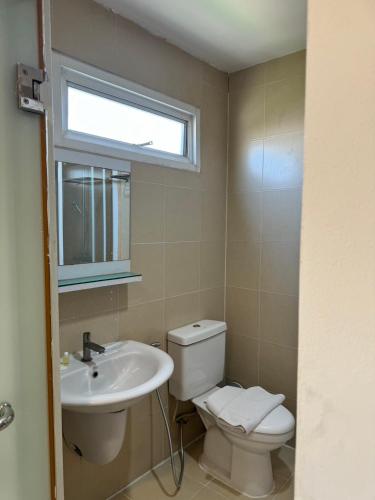 a bathroom with a toilet and a sink and a window at GP House Express Sukhumvit 81 in Bangkok