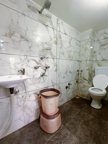 a bathroom with a toilet and a sink at Hotel Shreem in Ujjain