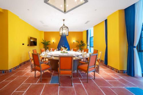 a dining room with yellow walls and a table and chairs at Xikang Wellness & Resort Qingcheng Mountain in Taiping