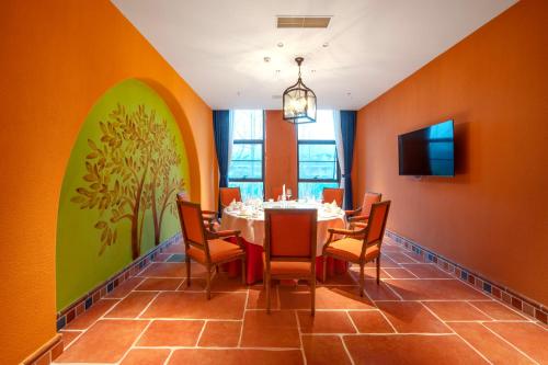 a dining room with orange walls and a table and chairs at Xikang Wellness & Resort Qingcheng Mountain in Taiping