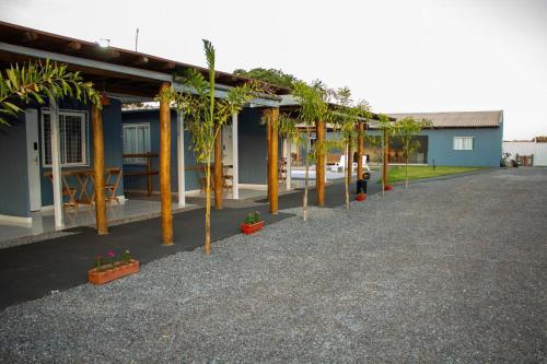 a row of trees in front of a house at Pousada Vila Rose Express Loft in Nobres
