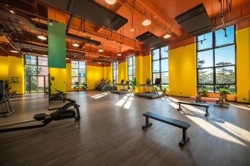 a gym with rows of exercise equipment in a large room at Xikang Wellness & Resort Qingcheng Mountain in Taiping