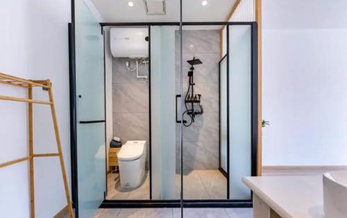 a bathroom with a glass shower with a toilet at 北京沐桐客栈 in Sanduhe