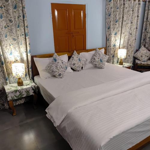 a bedroom with two beds and two lamps on tables at Marwa House in Jaipur