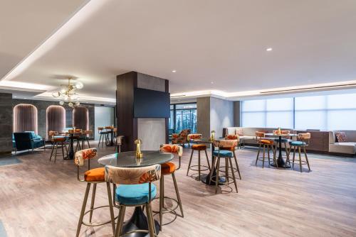 a lobby with stools and tables in a building at Doubletree By Hilton Amman Hotel & Residences in Amman