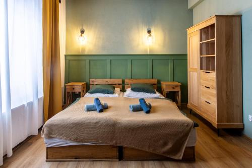 a bedroom with a bed with two blue pillows on it at Folwark Wierzchy in Wierzchy