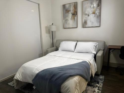 弗赖拉辛Modern & Cozy Apt with pool in prime location的卧室内的一张床铺,墙上有两张照片