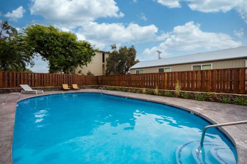 a swimming pool in a yard with a wooden fence at Kona 1br condo on Alii Dr saltwater pool surf sun AC close to magic sands beach in Kailua-Kona