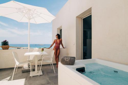 a woman in a bikini standing next to a bath tub at Makrikythera Luxury Suites - Private Pool or Hot Tub Suites in Dhiakofti