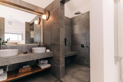a bathroom with two sinks and a shower at Makrikythera Luxury Suites - Private Pool or Hot Tub Suites in Dhiakofti