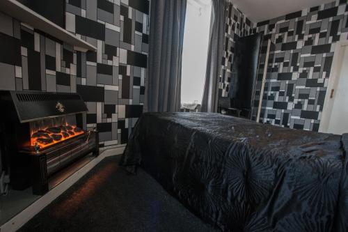 a bedroom with a fireplace in front of a bed at The Carlton Hotel in Folkestone
