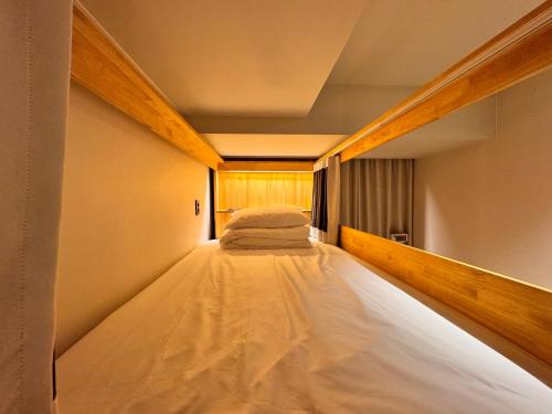 a long bed in a small room with at Bluedot Poshtel in Seoul