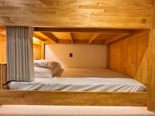 a bunk bed in a room with wooden walls at Bluedot Poshtel in Seoul