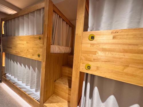 two wooden bunk beds in a room at Bluedot Poshtel in Seoul