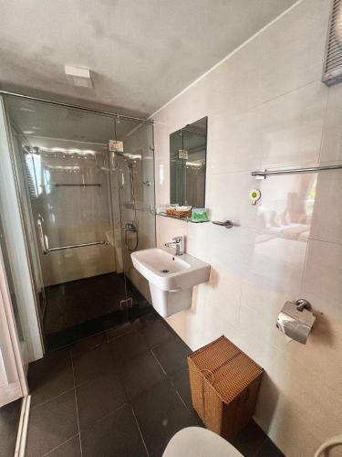 a bathroom with a sink and a shower and a toilet at Little Garden Bungalow in Phú Quốc