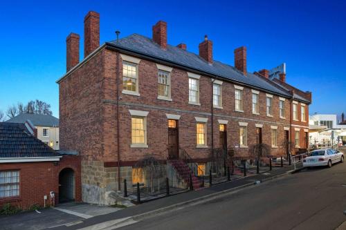 a brick building with a car parked in front of it at Portsea Place - Chic queen studio and parking in Hobart