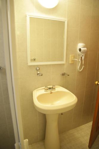 a bathroom with a sink and a mirror at Suites Poliforum Inn in León