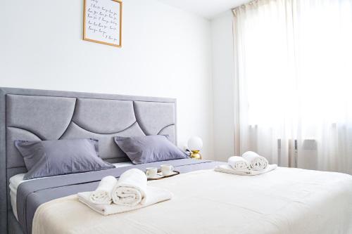 a white bedroom with two beds with towels on them at Apartment Stefani Zadar - Balcony & Free Private Garage Parking in Zadar