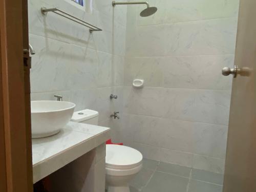 a white bathroom with a sink and a toilet at Home of Joy Villa Peace House in Dasmariñas