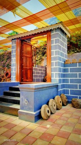 a house with a porch with steps and a door at Madhura Agro Tourism in Wai