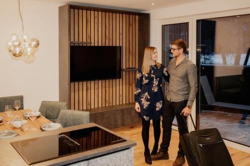 a man and a woman standing in a living room at Das Goldjuwel - Luxury Apartments with private Spa in Goldegg