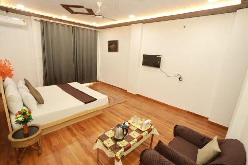 ウダイプールにある2 Bhk Udaisagar Homestay Udaipurのベッドとソファとテーブルのある寝室