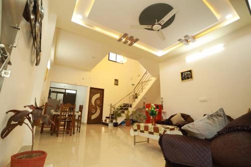 ウダイプールにある2 Bhk Udaisagar Homestay Udaipurのソファと天井ファンのあるリビングルーム