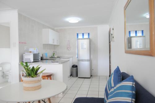 a kitchen with a table and a refrigerator at Mzingazi Waterfront Accommodation, On The Bay Waterfront Villa's in Richards Bay