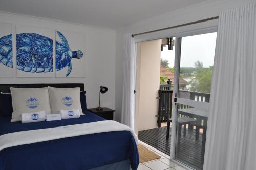 a bedroom with a bed and a balcony at Mzingazi Waterfront Accommodation, On The Bay Waterfront Villa's in Richards Bay