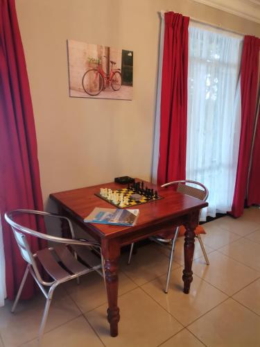 a chess board on a table with two chairs at Green Hills Farm House in Drummond