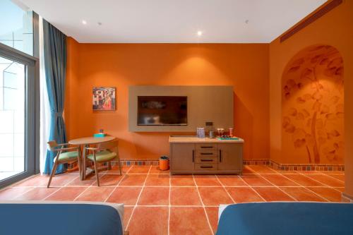 a living room with orange walls and a table at Xikang Wellness & Resort Qingcheng Mountain in Taiping