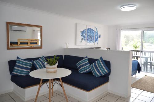 a blue couch in a living room with a table at Mzingazi Waterfront Accommodation, On The Bay Waterfront Villa's in Richards Bay