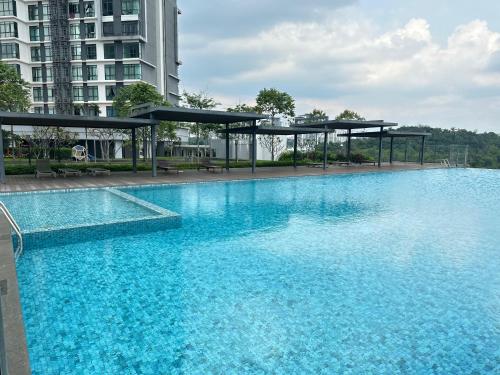 a large pool with blue water in a building at Kenwingston Cyberjaya Wifi Free Parking in Cyberjaya