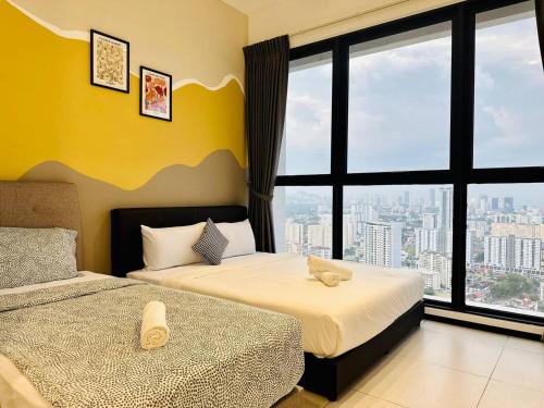 Un dormitorio con dos camas y una gran ventana. en Home Away From Home in Penang, en Jelutong