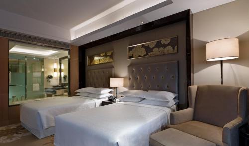 En eller flere senger på et rom på Sheraton Daqing Hotel