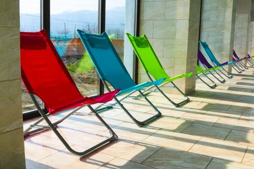 a row of colorful chairs sitting in front of a building at Camves Inn in Sighetu Marmaţiei