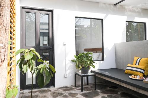 a porch with a bench and two potted plants at veHaa BOUTIQUE HOTEL in Phnom Penh