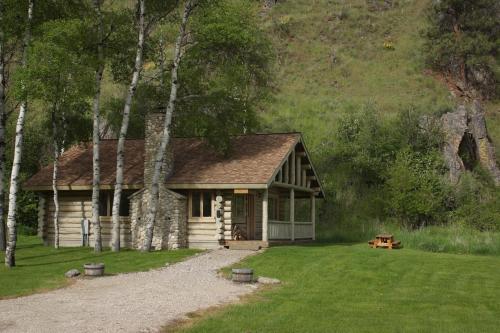 a log cabin in the middle of a yard at Rye Creek Lodge in Darby