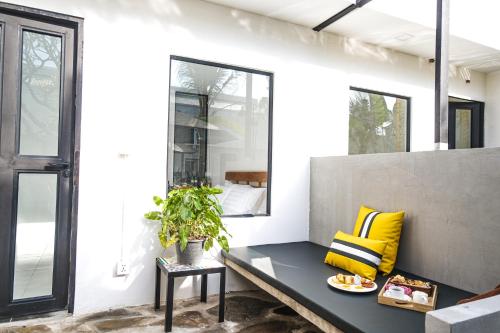 a living room with a black bench and yellow pillows at veHaa BOUTIQUE HOTEL in Phnom Penh