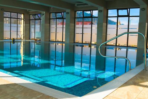 ein Pool mit blauem Wasser in einem Gebäude in der Unterkunft Camves Inn in Sighetu Marmaţiei