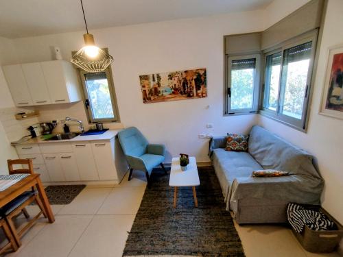 a living room with a blue couch and a kitchen at Tavor view נוף תבור in Daverat