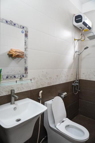 a bathroom with a white toilet and a sink at Phong Nha Orient Homestay in Phong Nha