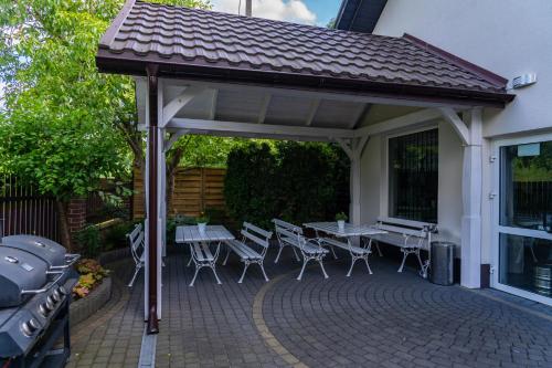 a pavilion with tables and chairs on a patio at Dom Wypoczynkowy Nad Wisłą in Puławy