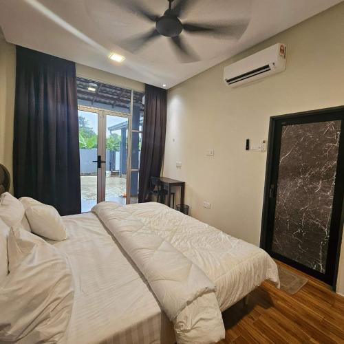 a bedroom with a bed with a ceiling fan at Sastred villa Mus'lim Only in Sungai Petani