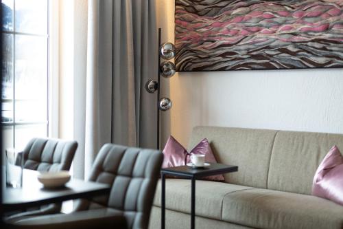 a living room with a couch and two chairs at Apart-Pension Bergland in Ladis