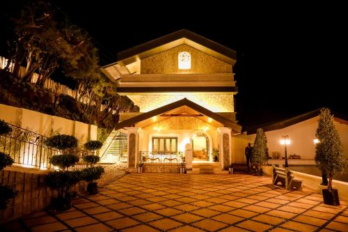 a building with a clock on top of it at night at Virgin Valley Leisure Resort in Ooty