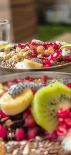 two plates of food with fruit and nuts on a table at BlaBla House Rishikesh in Rishīkesh