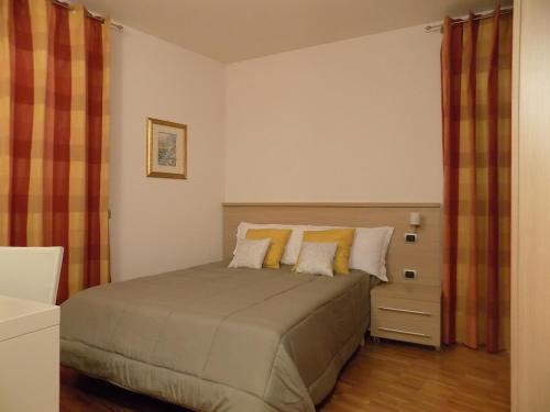 a bedroom with a bed with yellow pillows at B&B Locanda Del Mulino in Pamparato